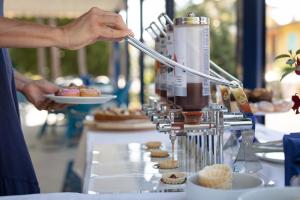 a person is holding a plate of pastries at Hotel Aspe in Bibione