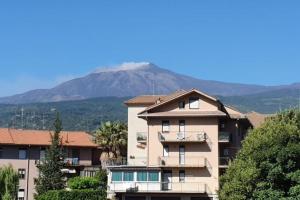 a apartment building with a mountain in the background at Appartamento Agrumi in Linguaglossa