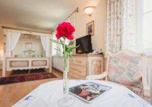 una rosa rossa in un vaso su un tavolo di Landgasthof Gietl a Kammern im Liesingtal