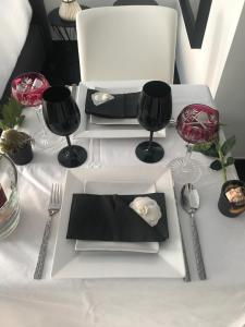 un tavolo bianco con un piatto bianco e un tovagliolo nero di Les lofts de Styliste a Bruxelles
