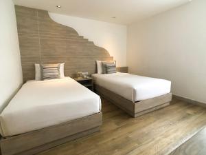 two beds in a room with a staircase at Methavalai Residence Hotel in Bangkok