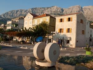 une ville avec des bâtiments et des montagnes en arrière-plan dans l'établissement Oldhouse Tučepi, à Tučepi