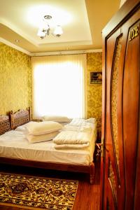 a bedroom with a bed and a window at Murod Yusufiy Boutique Hotel in Bukhara