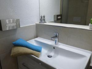 un lavabo blanco con una toalla azul. en Pirna-Apartment, en Pirna