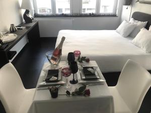 Un dormitorio con una cama y una mesa con una botella de vino en Les lofts de Styliste, en Bruselas