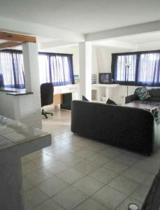 a living room with a couch and some windows at Hotel Restaurant Hellenique Appartements in Kigali