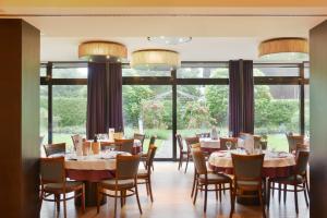 uma sala de jantar com mesas e cadeiras e uma grande janela em Hotel Weisses Kreuz em Feldkirch