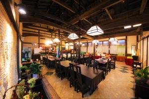 a dining room with tables and chairs in a restaurant at Sakura Sakura Onsen in Kirishima