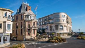 a large building with a clock on the front of it at Royal Emeraude Dinard - MGallery in Dinard
