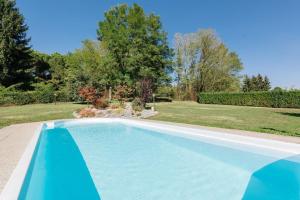 a blue swimming pool in a yard with trees at Villa Rosalia in Olgiate Comasco