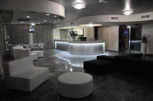 a lobby with white furniture and a bar in the background at Olympus Resort in Alba Adriatica