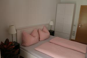 een bed met roze kussens erop bij Appartment Larcher - Meinhard in Merano +25 foto's