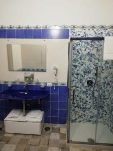 ein Bad mit einer Dusche und einem blauen Waschbecken in der Unterkunft B&B Notte d'autore in Agropoli