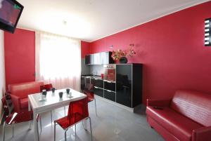 ein Wohnzimmer mit roten Wänden, einem Tisch und Stühlen in der Unterkunft Olympus Resort in Alba Adriatica