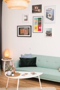 ein Wohnzimmer mit einem blauen Sofa und einem Tisch in der Unterkunft Spittelau Chillout Lounge upto7P spacious bright contactless24h in Wien