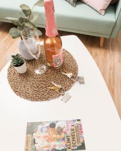 uma garrafa de vinho e uma revista sobre uma mesa em Spittelau Chillout Lounge upto7P spacious bright contactless24h em Viena