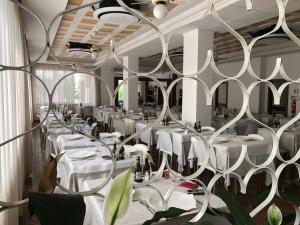 jadalnia z białymi stołami i białymi krzesłami w obiekcie Hotel Florence w mieście San Benedetto del Tronto