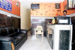 a man standing at a bar in a waiting room at Shubhanga Residency in Srikalahasti