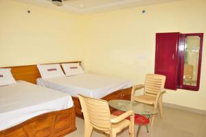 Shubhanga Residency tesisinde bir odada yatak veya yataklar