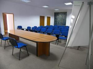 una sala de conferencias con una mesa de madera y sillas azules en Tarnowskie Centrum Informacji en Tarnów