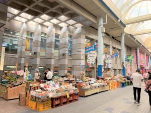 ein Markt mit Menschen, die in einem großen Gebäude herumlaufen in der Unterkunft “Okawa Stay” Five-Bedroom Condo in Ishigaki-jima