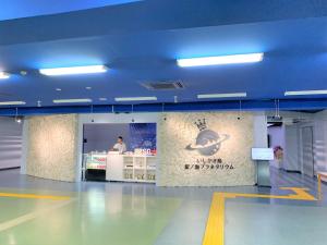 Ein Mann steht an einem Tresen in einem Gebäude in der Unterkunft “Okawa Stay” Five-Bedroom Condo in Ishigaki-jima