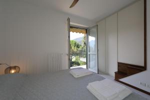 una camera da letto con un letto e una grande finestra di Tasso 10 a Bellagio