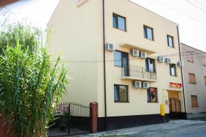 a building with a fence in front of it at Pensiunea Vlad in Arad