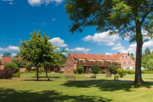 un edificio con bancos y árboles en un parque en Ferienpark Mecklenburg, en Ziegendorf
