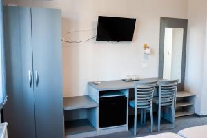 a room with a desk with chairs and a tv at Pensiunea Vlad in Arad