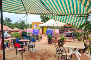 a patio with tables and chairs under an umbrella at Dreamz Recreation Center in Jinja