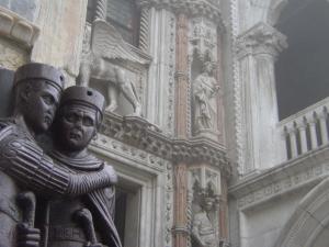 a pair of statues on the side of a building at Apartment Essence of Venice in Venice