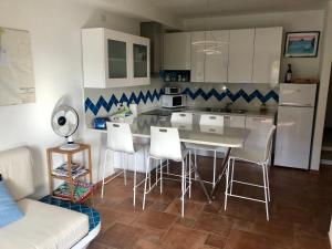 特乌拉达Villa Perdalonga, Vista Mare Sea View Tuerredda的配有桌椅和沙发的厨房