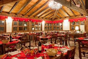 a dining room with tables and chairs and a chandelier at Rifugio del Firenze Ninfa in Sestola