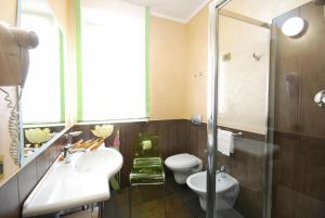 ein Badezimmer mit Waschbecken, Toilette und Dusche in der Unterkunft Olympus Resort in Alba Adriatica + 25 Fotos