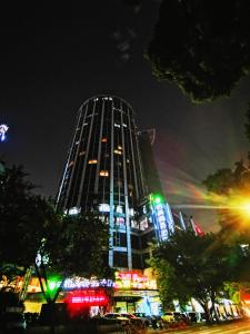a tall building with lights on it at night at Paco Hotel Tuanyida Metro Guangzhou -Free ShuttleBus for Canton Fair in Guangzhou
