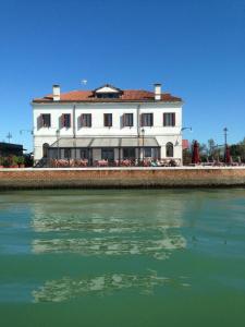 a large white building next to a body of water at Antica Dogana in Cavallino-Treporti