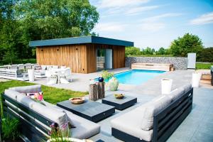 Zemstakemi b&b的后院庭院,带游泳池和大楼