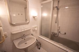 a bathroom with a sink, toilet and bathtub at Fletcher Hotel Restaurant Marijke in Bergen