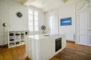 - une cuisine blanche avec évier et cuisinière dans l'établissement NOCNOC - Les Trois Grâces, à Montpellier