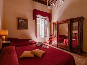 a bedroom with a red bed and a red couch at B&B Siena In Centro - Diffuso in Siena