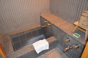 a bathroom with a shower with a toilet and a sink at Kumamoto Hotel Castle in Kumamoto