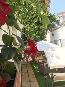 un jardín con una mesa y flores en un balcón en Virgilio’s Garden, en Castellammare di Stabia