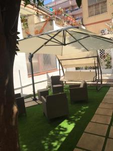 a patio with a table and chairs on the grass at Virgilio’s Garden in Castellammare di Stabia