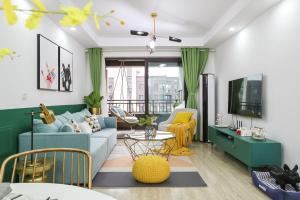 ein Wohnzimmer mit einem blauen Sofa und einem Tisch in der Unterkunft lu ke boutique apartment 00123370, qixiashan nanjing station, nanjing city, jiangsu province in Nanjing