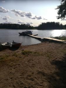 two boats are docked at a dock on a lake at Pirttiniemen Lomakylä in Muurasjärvi