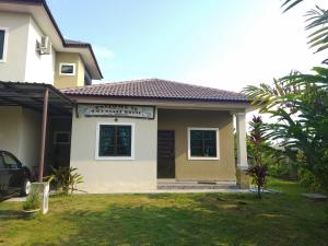 una casa con un coche aparcado delante de ella en HMA Guesthouse en Sepang