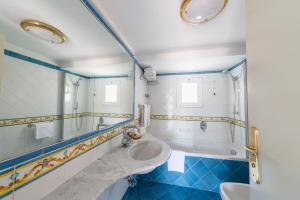 a bathroom with two sinks and a tub at Hotel Continental Ischia in Ischia