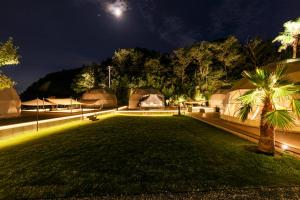 a night view of a camp with tents in a field at sana mane in Naoshima