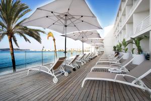a row of white chairs and umbrellas on a deck at BG Nautico Ebeso in Ibiza Town